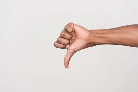 Thumb down hand signs isolated on white. black man hand gesturing with hand on whiteの写真素材