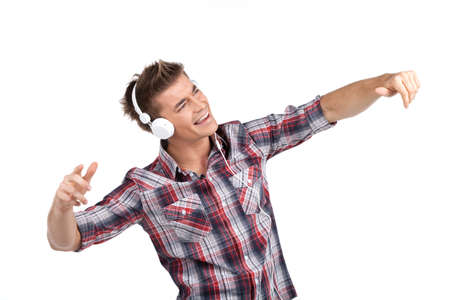 young man enjoying music on headphones. waist up portrait of boy isolated on white while listening to musicの写真素材