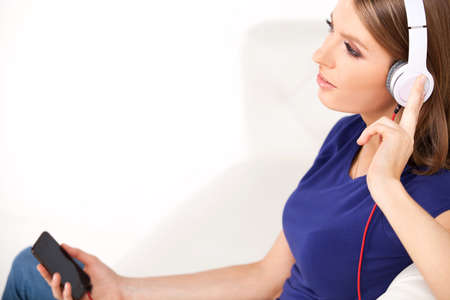 beautiful young girl listens to music on headphones.の写真素材