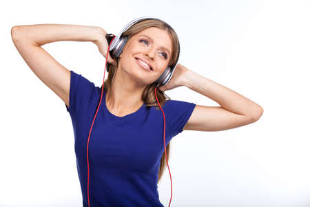 Cheerful young woman listening music with headphones. の写真素材
