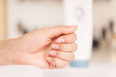 Woman in nail salon receiving manicure. closeup image of female hands and fingers resting on towelの写真素材