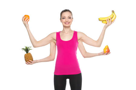 beauty brunette with fruits on white background. girl with four hands holding different fruits and smilingの写真素材