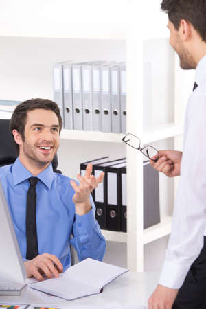 two businessmen having discussion in office. Two Businessmen Having Informal Meeting In Modern Officeの写真素材