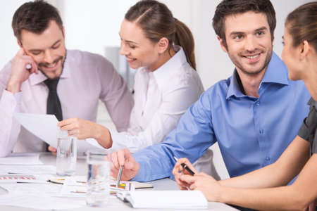 Group of young business people talking in couples. business man and woman working on meeting in officeの写真素材