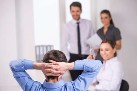 Group of young business people talking on business meeting. back view of man sitting at meeting in officeの写真素材