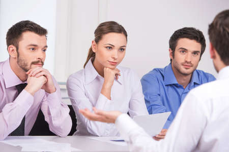Group of young business people talking on business meeting. over shoulder view of man sitting at meeting in officeの写真素材
