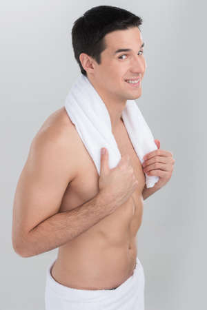 side view studio picture of young naked man. Young handsome man after bath with white towelの写真素材