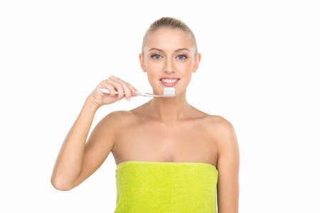 Closeup of beautiful young lady holding toothbrush and smiling. pretty blond girl cleaning her teeth with toothbrushの写真素材