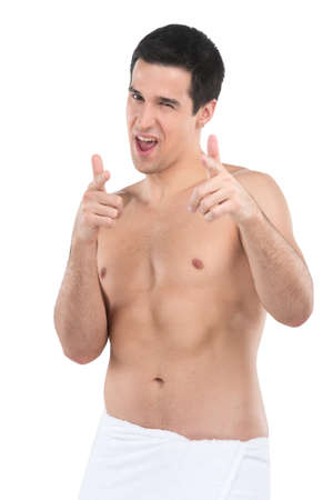 attractive young man pointing finger towards you. Shirtless young man pointing forward with towel aroundの写真素材