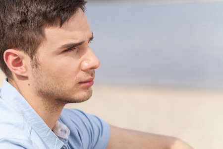 Head and shoulder profile portrait of handsome man on beach. の写真素材