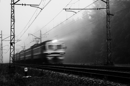 misty country railroad in the early morning with train incomingの写真素材