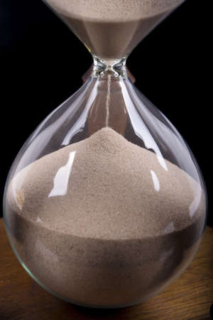 Wooden hourglass detail on black background