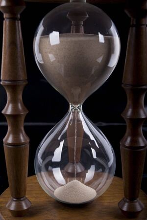 Wooden hourglass detail on black background