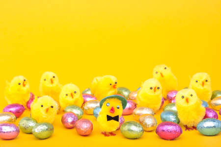 Easter eggs and chicks over yellow backgroundの写真素材