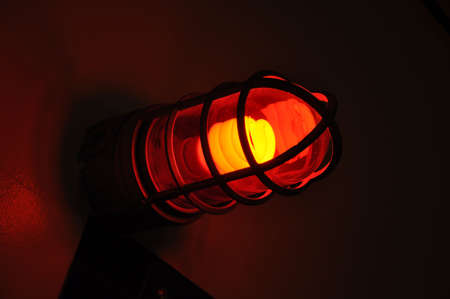 Illumination of a red lightbulb facing rightの写真素材