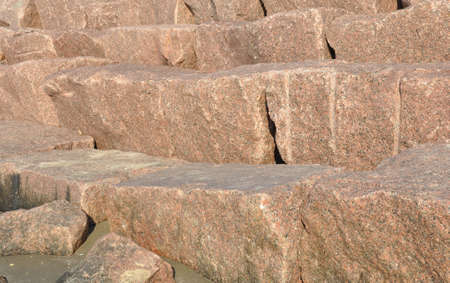closeup of a granite seawall in the sunlightの写真素材