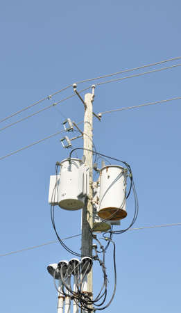 Electrical transformer against a bright blue sky