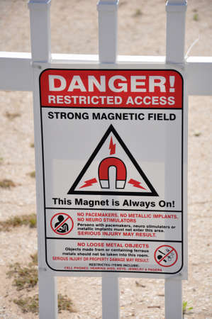 A sign reading Danger Restricted Access Strong Magnetic Fieldの写真素材