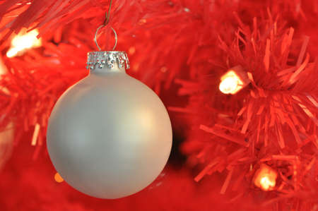 A silver ball ornament against a red backgroundの写真素材