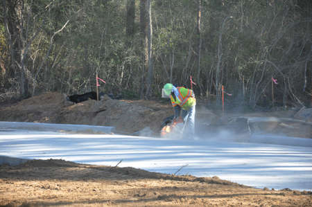 a single construction worker cutting a new roadの写真素材