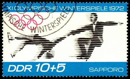 GDR - CIRCA 1972: a stamp printed by GDR shows figure skating , circa 1972 in Sapporo, Japanのeditorial素材