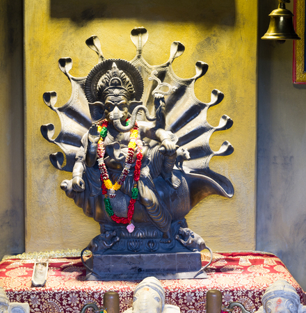 hindu god ganesh with yellow background and bellの写真素材