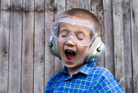 Little boy with safety glasses on wooden backgroundの写真素材
