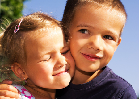 portrait of two little kids on blue sky backgroundの写真素材