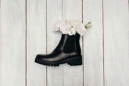 Stylish Winter Boots decorated with flowers on a wood texture. Fashion Trendsの写真素材