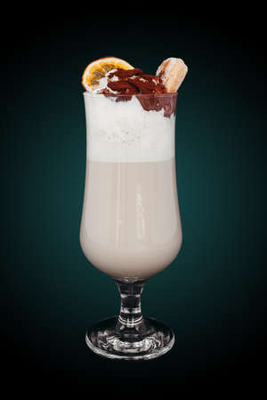 Delicious Milkshake in glass cup isolated on blue gradient. Refreshing drinkの写真素材