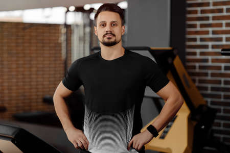 Portrait of personal trainer in sports outfit in fitness center gym standing strongの写真素材