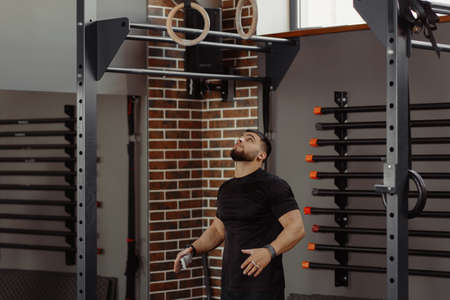 Muscular young man prepare to doing intense workout on gymnastic rings. Crossfit or Strength workout.の写真素材