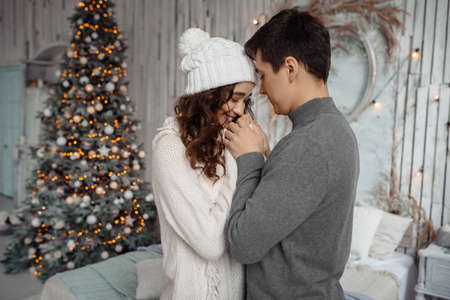 Happy young lovely couple enjoys each other on New Years Eve in a cozy home environment. New Years love story.の写真素材
