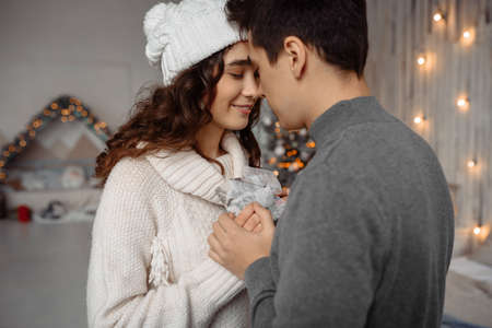 Happy young couple with Christmas presents enjoying family cozy moments during New Year holidaysの写真素材