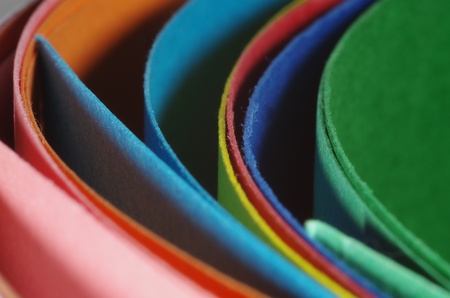 An overhead abstract view of colourful curved cardboard folders for office or school.