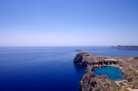 View over the rocky coastline and St Paul Bay, Lindos, Rhodes, Greece with copyspaceの写真素材