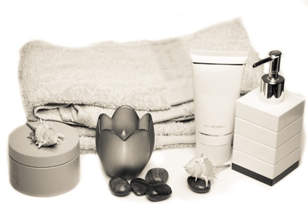 Fresh spa still life in neutral shades with a towel, massage stones, candle and various containers...