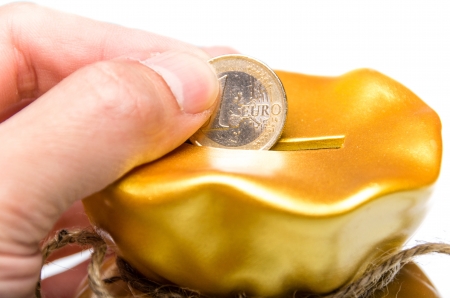 A coin is deposited through a slit to save moneyの写真素材