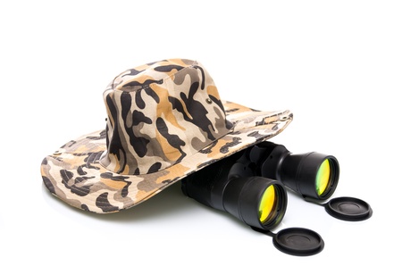 Binoculars and a safari hat on a white background conceptual of travel, adventure and eco-tourism or a wildlife safariの写真素材