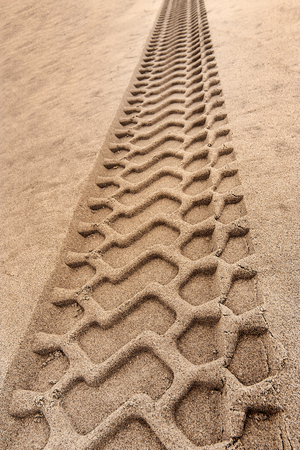tire tracks prints in sand on a beachの写真素材