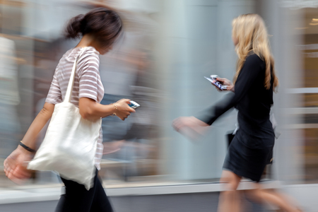people shopping in the city in motion blurの写真素材