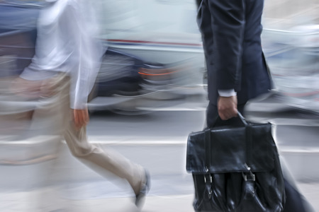 Business people at rush hour walking in the street, in the style of motion blur