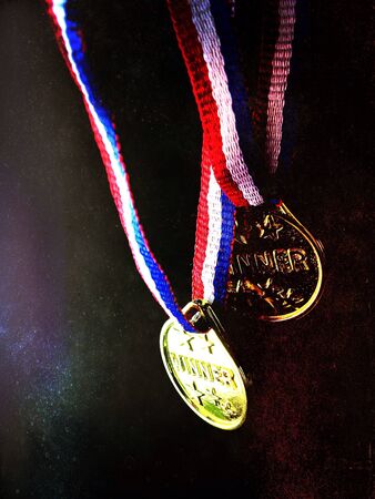 Two medals with the word winner with special black background with reflectionの素材