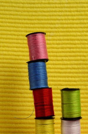 close view of colorful rolls of coton,in pile with a yellow background