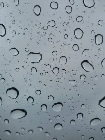 Closeup view of drops of rain in glassの素材