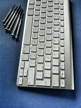 Close view of isolated keyboard and set of precision screwdriversの素材