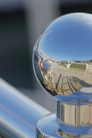 A chromed knob reflects the dock of a harborの写真素材