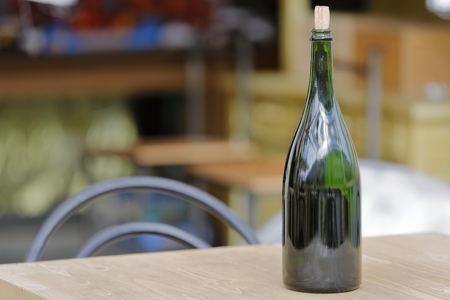 a bottle of wine comes in a table in a barの写真素材