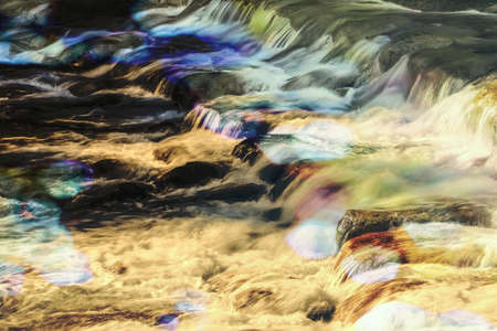 multicolored in the water of a mountain streamの写真素材