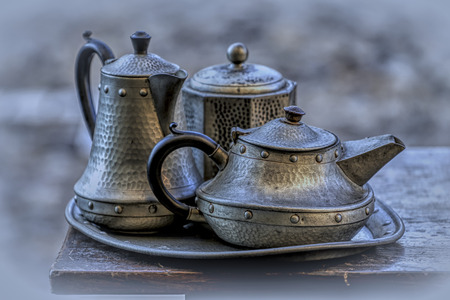 antique pewter tea service on a solid wood tableの写真素材